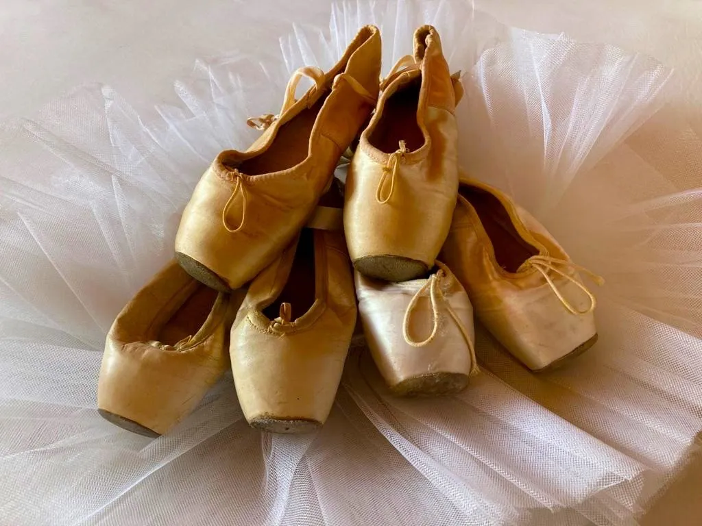 Goldene Spitzenschuhe auf einem Tüllrock
