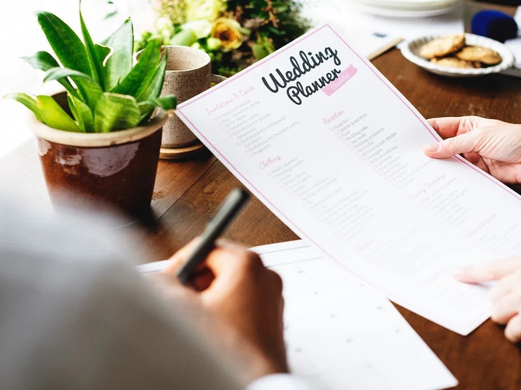 Hochzeitsplaner mit Notizbuch und Ringen